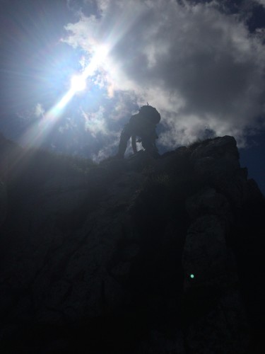 Sohn am Kletterfelsen. Mit Gegenlicht.