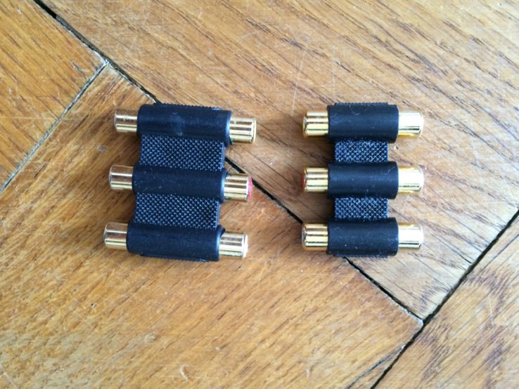 Zwei Stecker, die man zwischen zwei Cinch-Kabel stecken kann. Für Audio und Video. In Gold! Wenn alles den Bach runtergeht, Gold besteht!